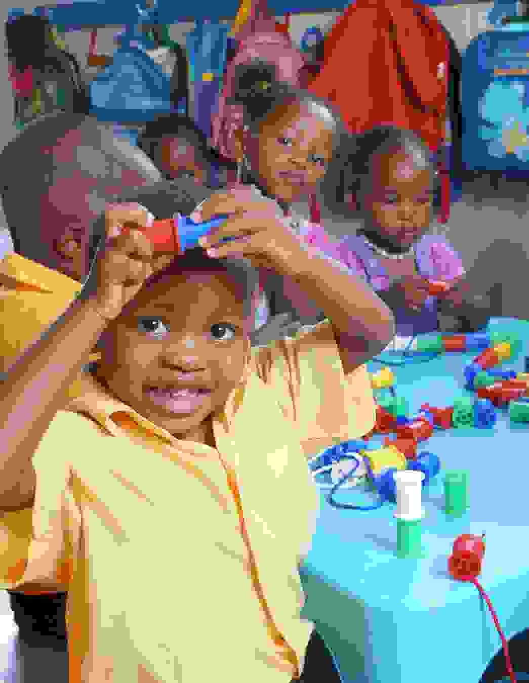 Kinder der KITA Nkululeko spielen mit bunten Rollen – ein lebendiges Bild davon, was Solidarität und Spenden möglich machen.