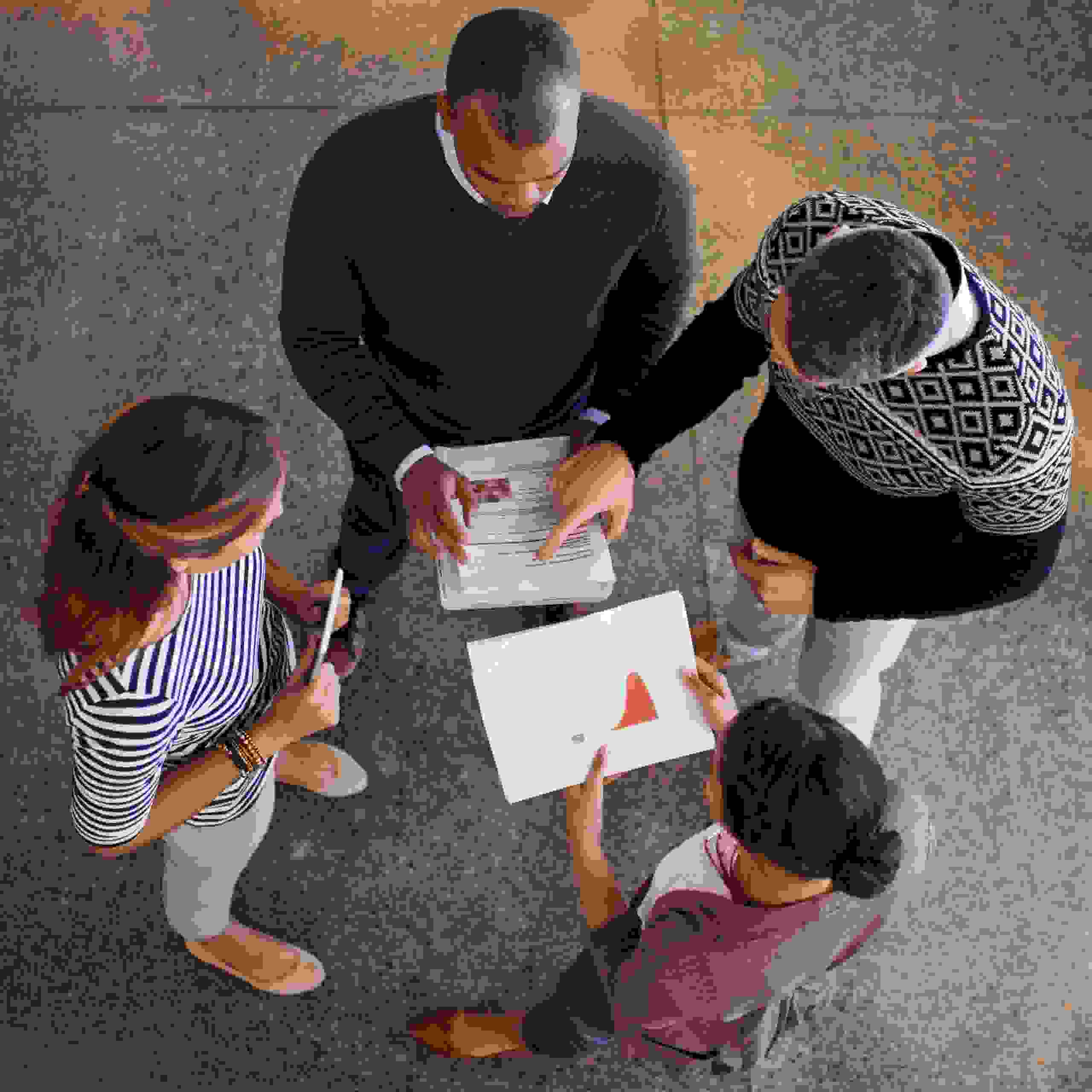 Quatre personnes discutent ensemble du contenu du rapport de gestion – l’image symbolise l’ouverture, le travail d’équipe et la responsabilité partagée pour une association transparente.