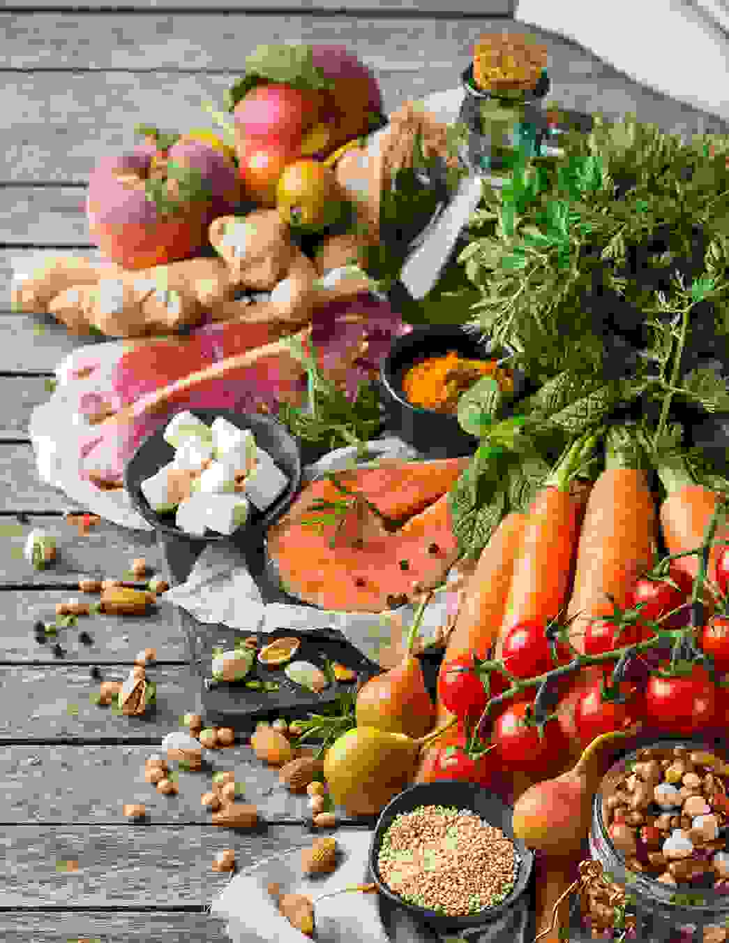 Eine bunte Auswahl an nährstoffreichen Lebensmitteln: rotes Fleisch, Lachs, Feta, Hülsenfrüchte, Gemüse und Obst – alles, was Mutter und Kind jetzt gut tut.