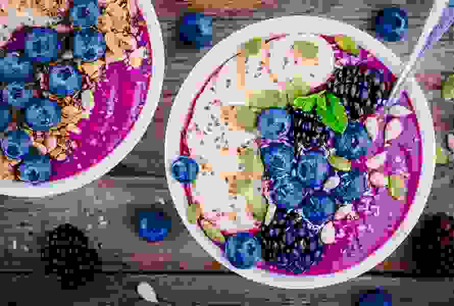 Ein gesundes Frühstück mit Joghurt, Banane, Brombeeren und Blaubeeren – idealer Start in den Tag für Schwangere.