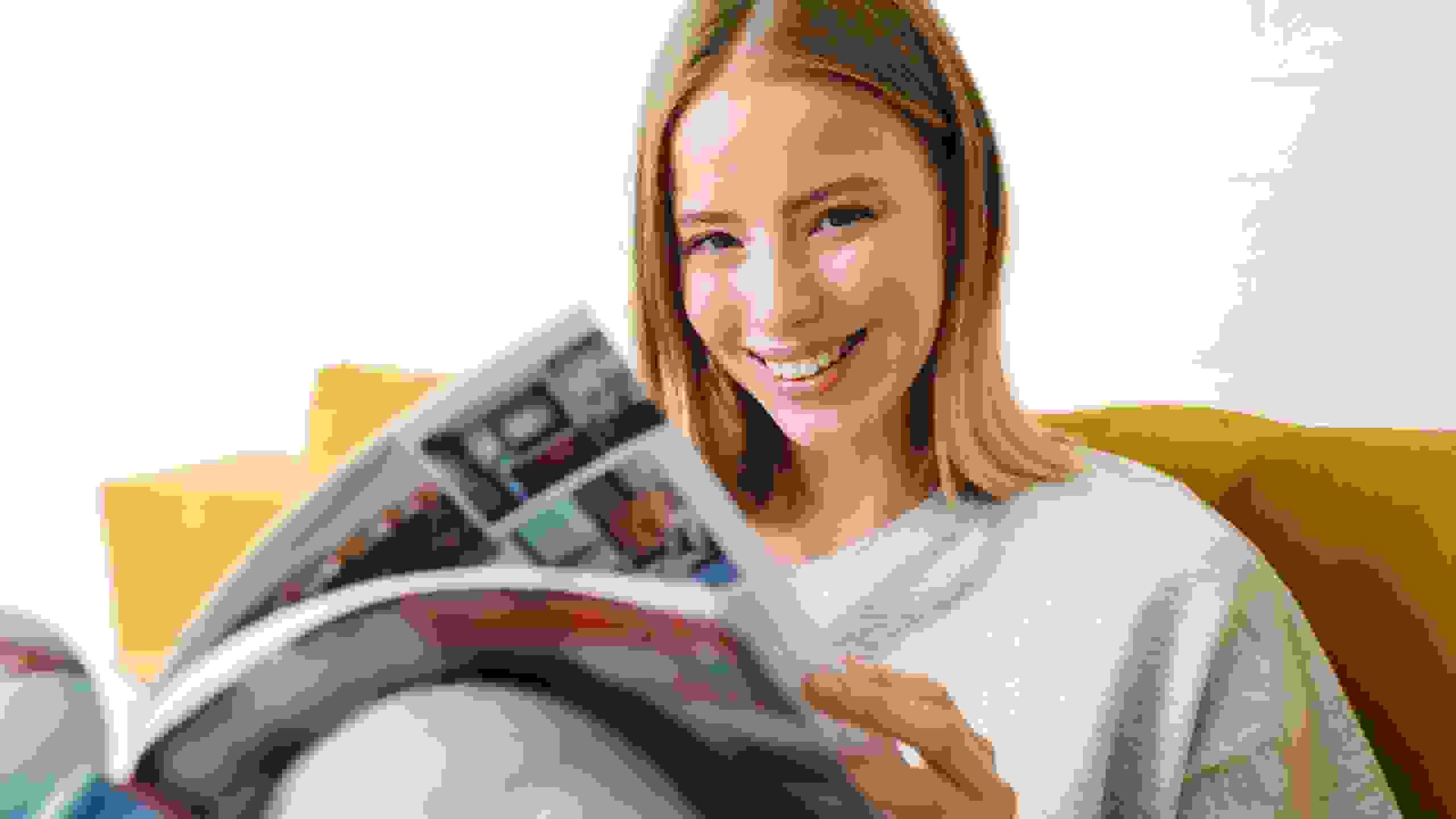 Eine junge Frau blättert interessiert in einem Magazin – ein Moment der Inspiration und des Verstehens, was PRO LIFE ausmacht.