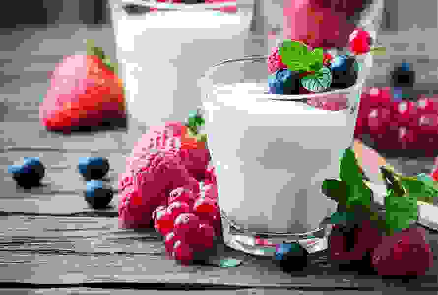 Un verre décoratif en couches avec du yogourt nature onctueux, des baies fraîches et des tranches de fruits. À côté du verre se trouvent quelques-uns des fruits utilisés. Léger, rassasiant et idéal contre les fringales.

