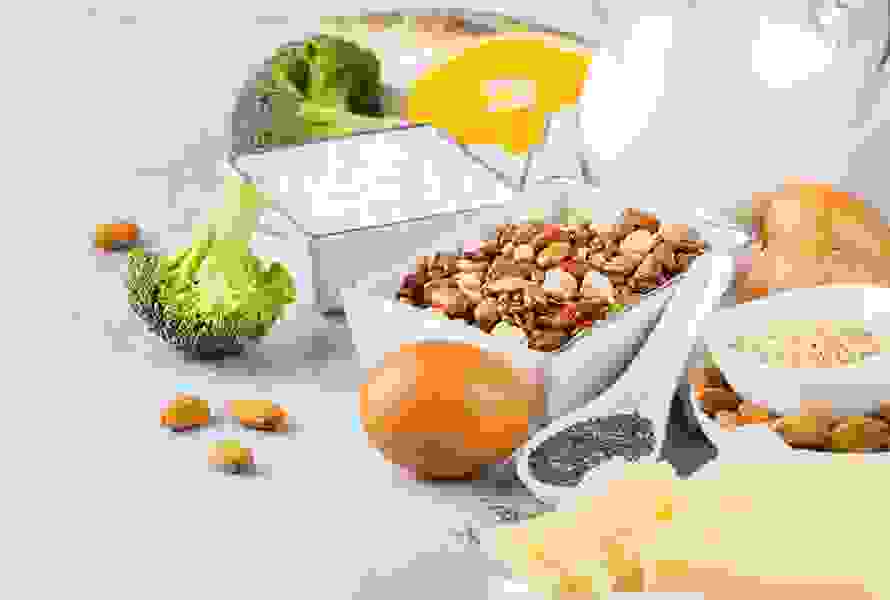 Eine bunte Auswahl an Hülsenfrüchten, Hüttenkäse, Broccoli, Eiern, Chiasamen, Mandeln und Käse – ideal für den täglichen Kalziumbedarf.