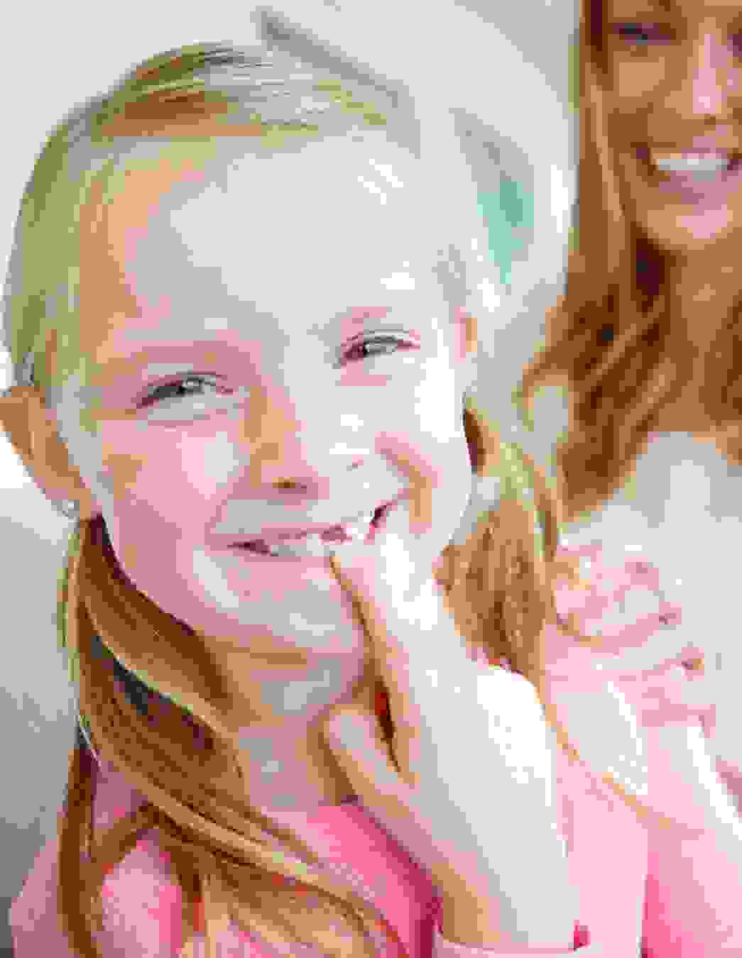 Une fillette suisse de cinq ans montre fièrement son espace entre les dents. Ce moment rappelle aux parents l’importance de penser tôt à une assurance dentaire adaptée.