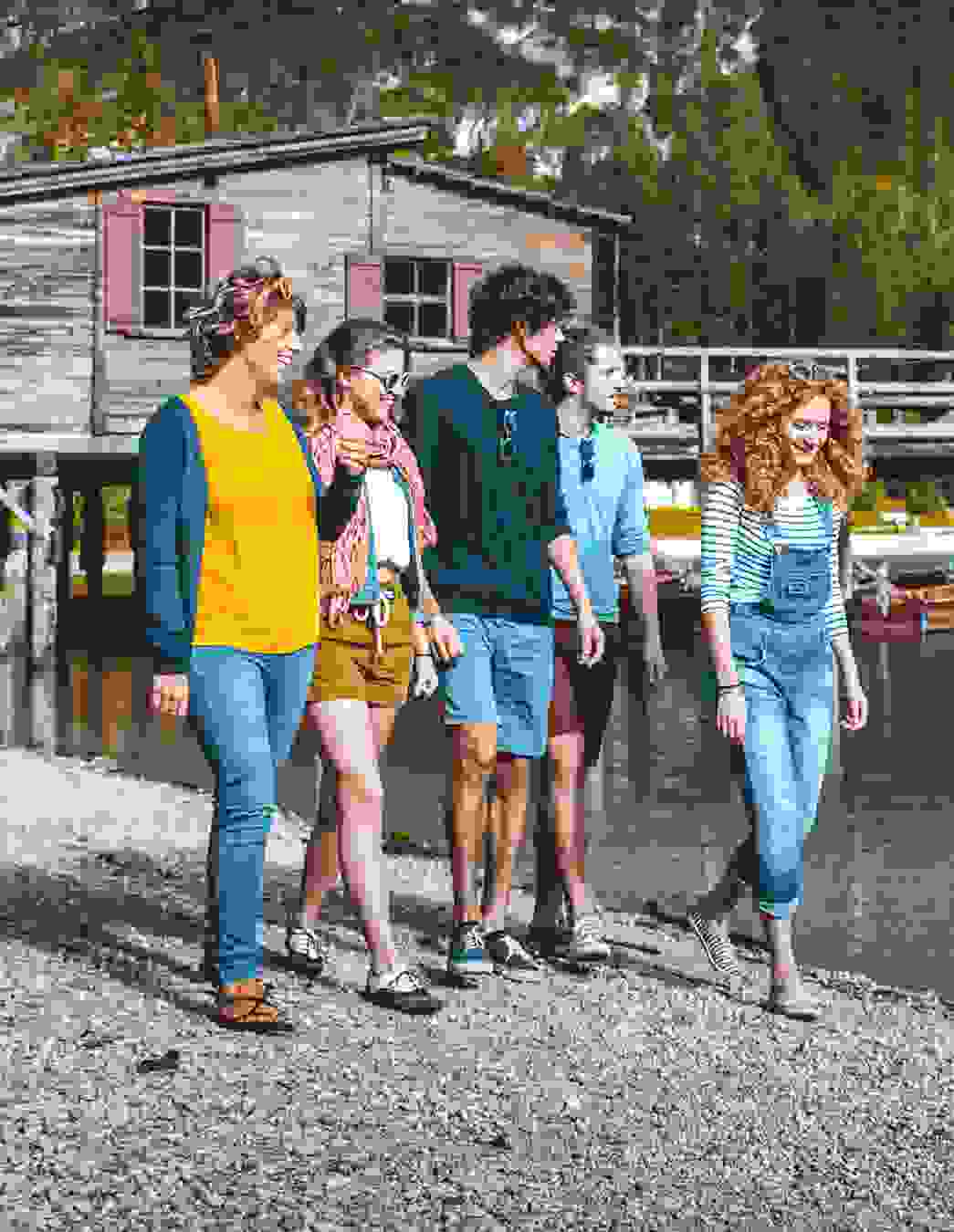 Cinq jeunes se promènent au bord du lac – un moment de légèreté qui montre ce que le temps libre avec MiBon peut signifier: communauté, nature et plaisir.