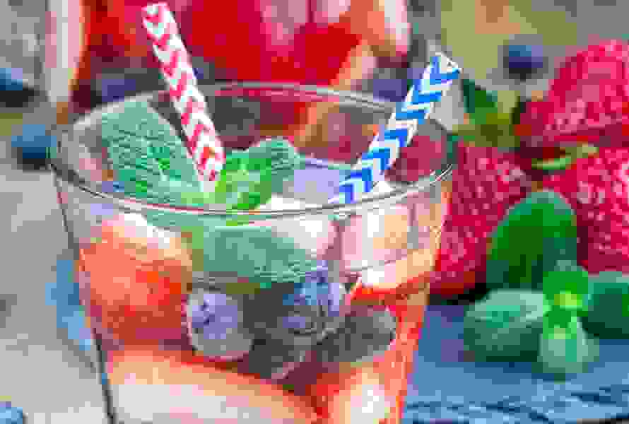 Ein Glas mit Wasser, gefüllt mit Blaubeeren und Erdbeeren – ein fruchtiger Hingucker und alkoholfreier Drink für Ihre Babyparty.