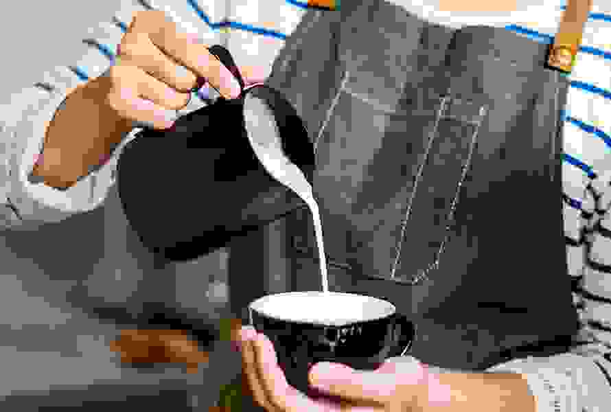 Eine Barista bereitet Kaffee zu – auch in der Schwangerschaft gilt es, den Konsum von Koffein im Blick zu behalten.
