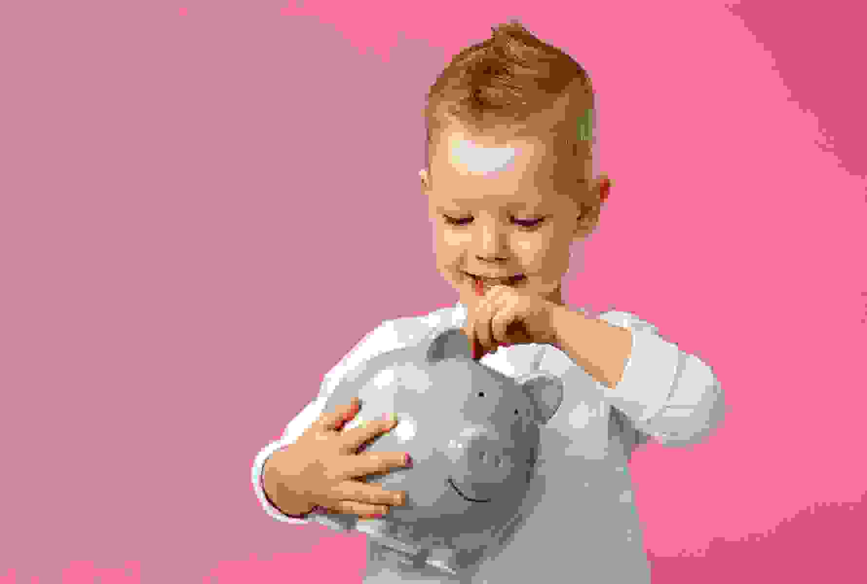 Le petit garçon met une pièce dans sa tirelire – c’est aussi simple que cela la solidarité.