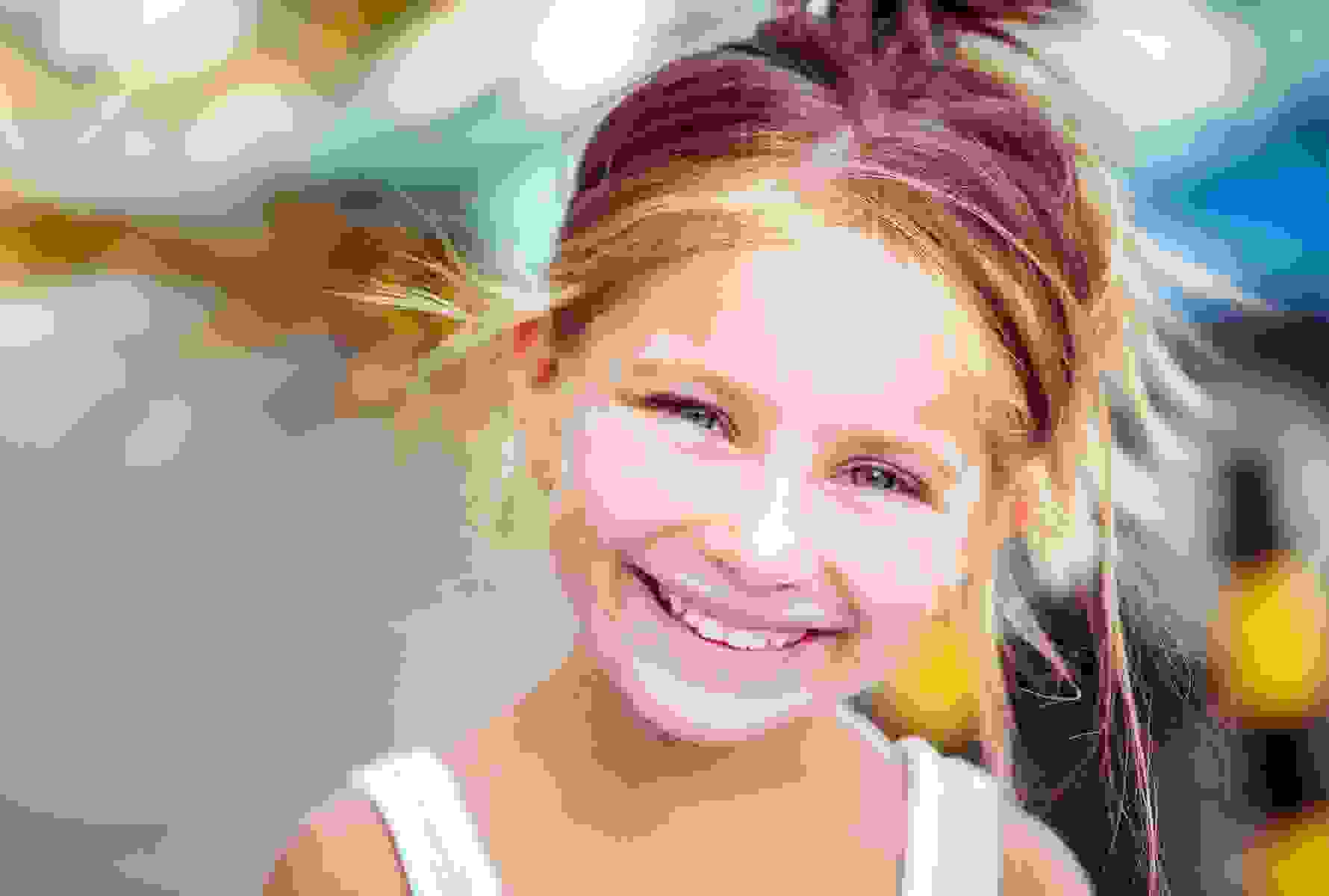 Une fillette joyeuse incarne des dents d’enfant saines – PRO LIFE vous soutient avec de solides prestations pour les soins dentaires et orthodontiques.