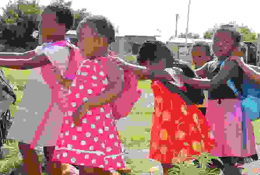 Die Kinder von Nkululeko marschieren lachend im Gänsemarsch – ein Moment voller Lebensfreude und Zusammenhalt auf ihrem Bildungsweg.