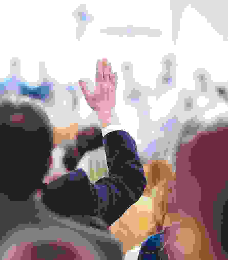 Una partecipante o un partecipante all’assemblea alza la mano per votare – un momento di democrazia associativa vissuta.