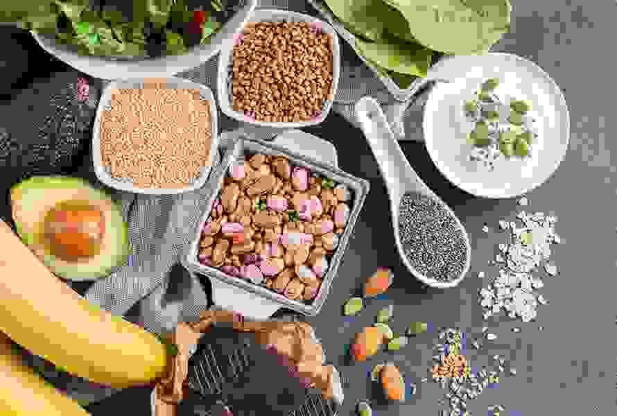 Verschiedene magnesiumreiche Lebensmittel wie Hülsenfrüchte, Quinoa, Quark, Spinat, Bananen und Mandeln – ideal zur Vorbeugung von Krämpfen und Müdigkeit.
