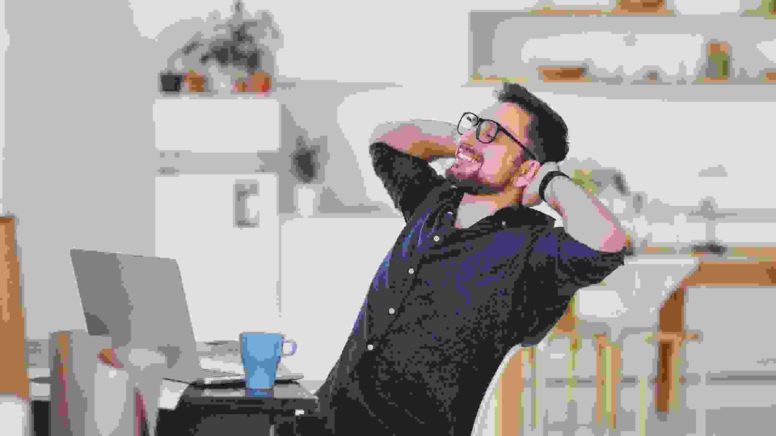 Un homme s’adosse, détendu, dans son fauteuil de bureau – une image de soulagement, de sécurité et de confiance en une communauté forte.