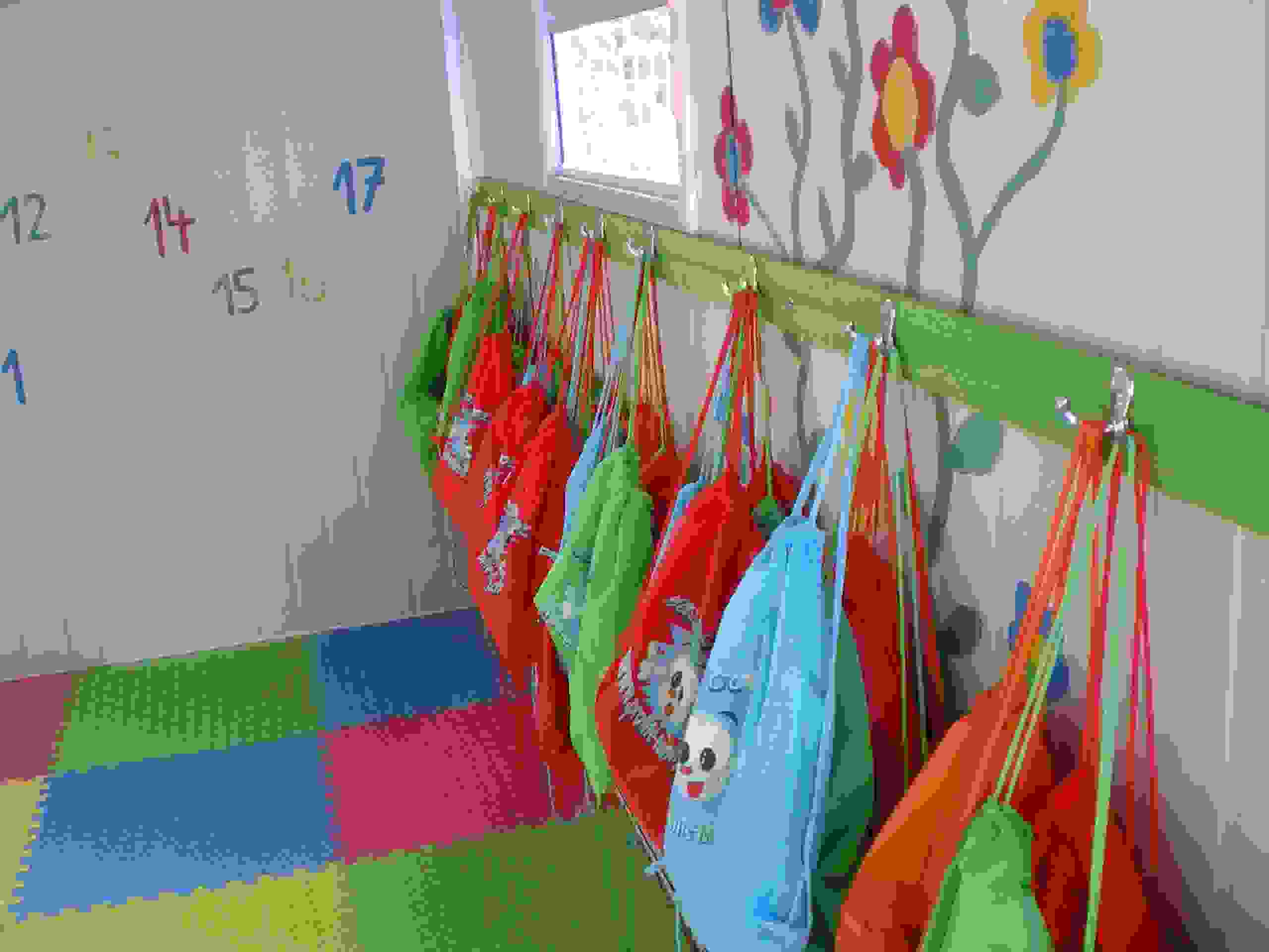 In der Garderobe hängen ordentlich die Schutzsäckchen der Kinder – ein Zeichen für Struktur, Fürsorge und gelebten Alltag.
