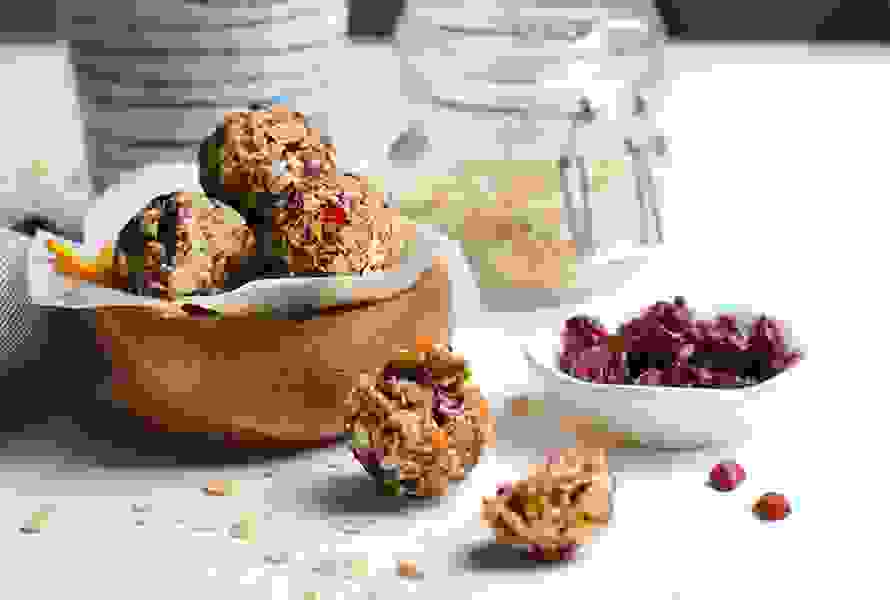 Selbstgemachte Stillkugeln aus Haferflocken, Cashewkernen, Datteln und Cranberrys mit milchbildenden Fenchelsamen – ein energiereicher Snack für Mütter im Wochenbett.