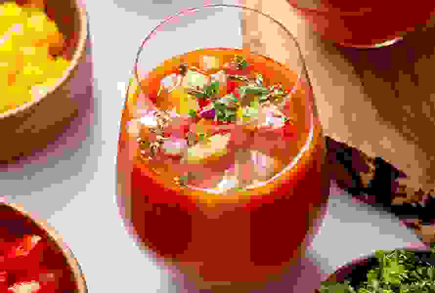 Ein Glas kalte Gazpacho, garniert mit bunten Gemüsewürfelchen – gesund, hydratisierend und perfekt für Schwangere mit wenig Appetit auf Wasser.