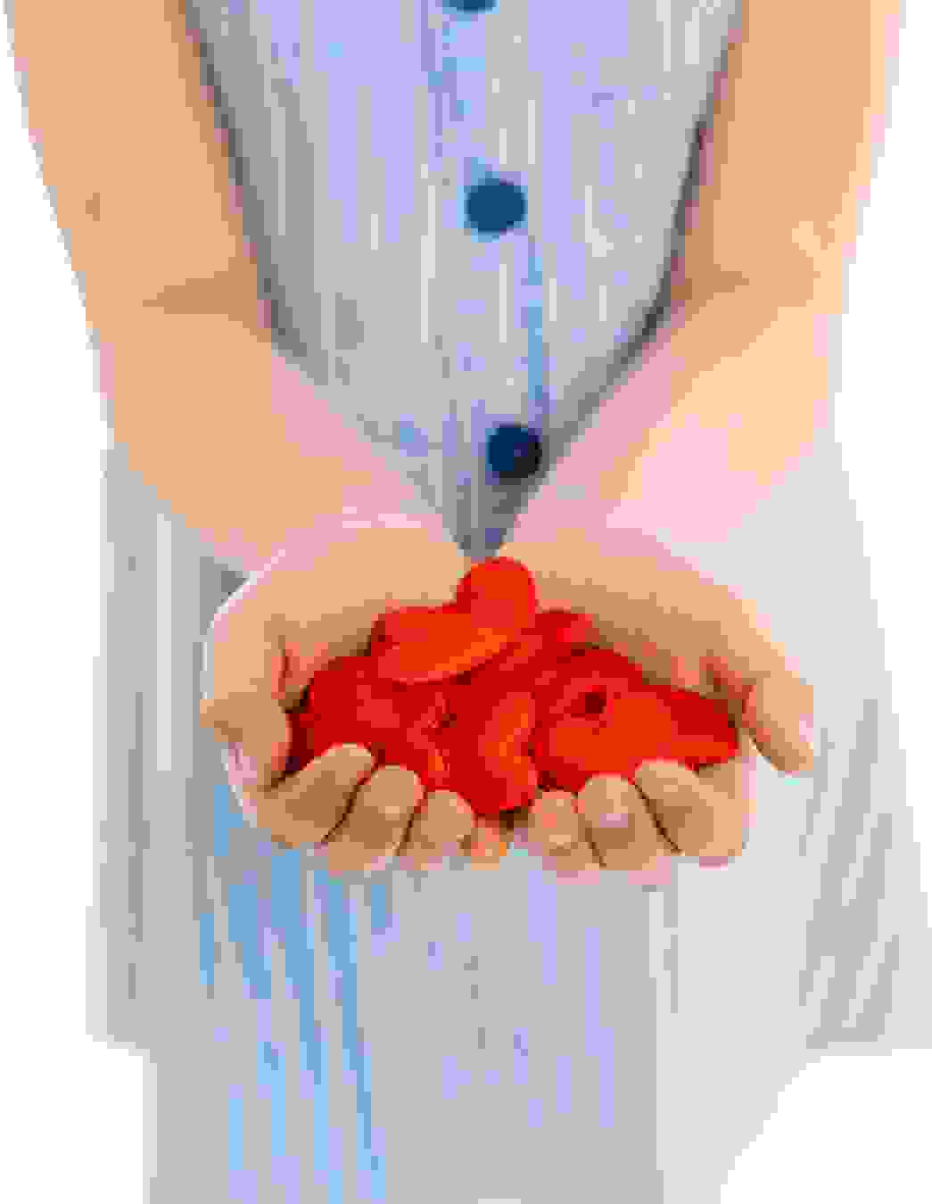 Une petite fille tient ses mains ouvertes – remplies de cœurs rouges. Une image émotive de bienveillance, de confiance et de soutien mutuel.