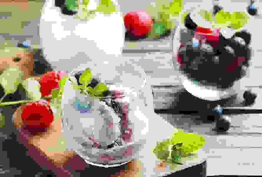 Ein Glas mit selbstgemachter Blaubeerglace und frischen Blaubeeren – eine gesunde, fruchtige Alternative zu klassischen Heisshungersnacks.
