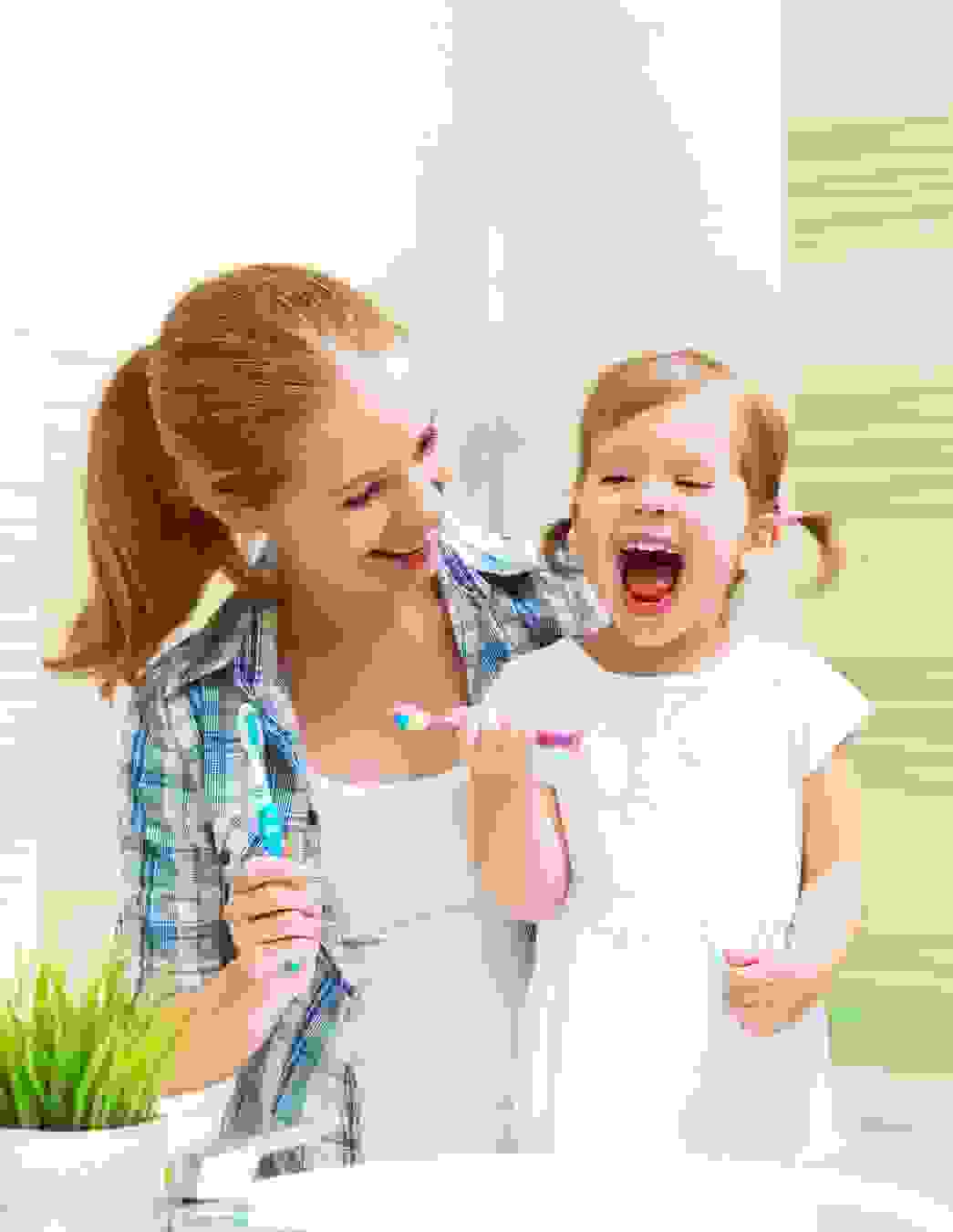 Una bambina è in piedi con la mamma davanti al lavabo – l’igiene dentale quotidiana inizia a casa, il sostegno finanziario arriva da PRO LIFE.