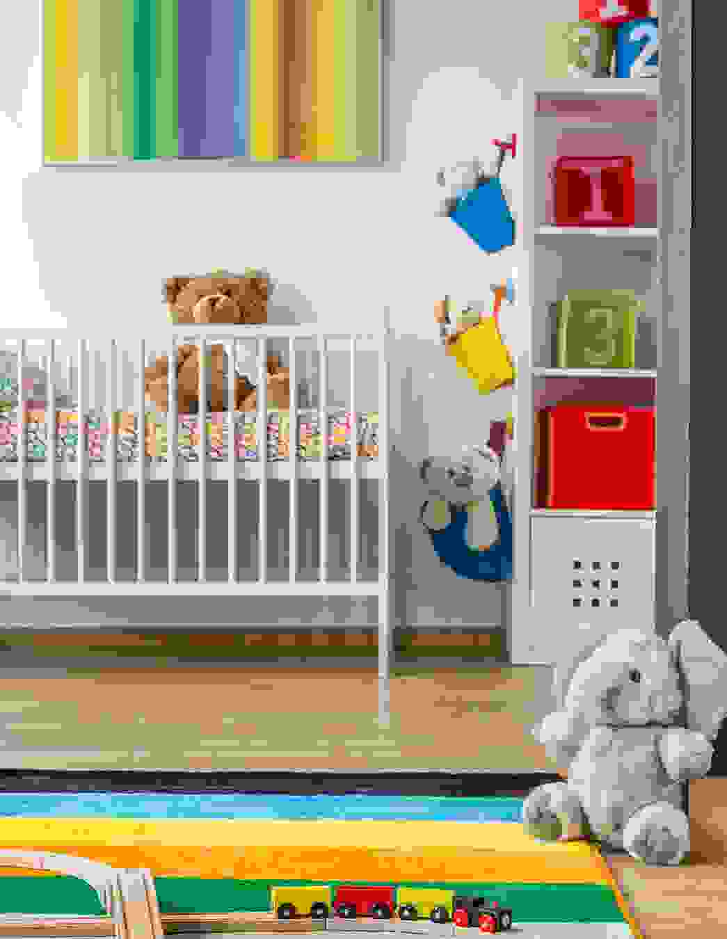 Ein liebevoll eingerichtetes Babyzimmer mit Bettchen, Teppich, Regal und Kuscheltieren – ein Bild, das den Wunsch widerspiegelt, alles noch vor der Geburt fertig zu machen.