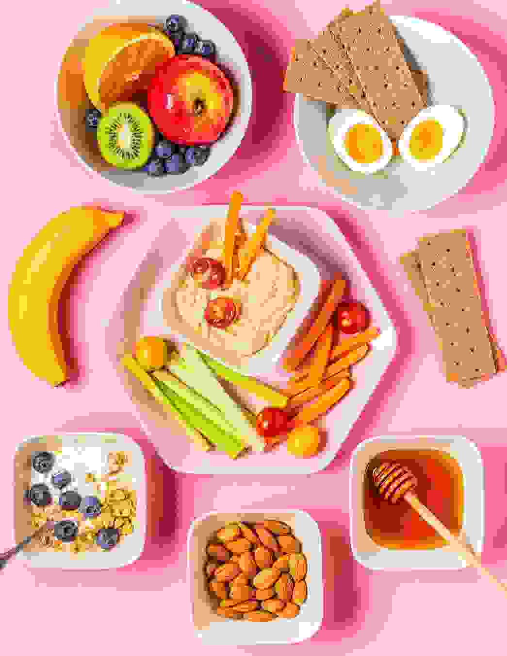 Ein gesunder Mix aus Hummus mit Gemüse, frischen Früchten, Nüssen, Honig, Vollkornknäckebrot und Ei – ideal, um Heisshungerattacken in der Schwangerschaft zu begegnen.