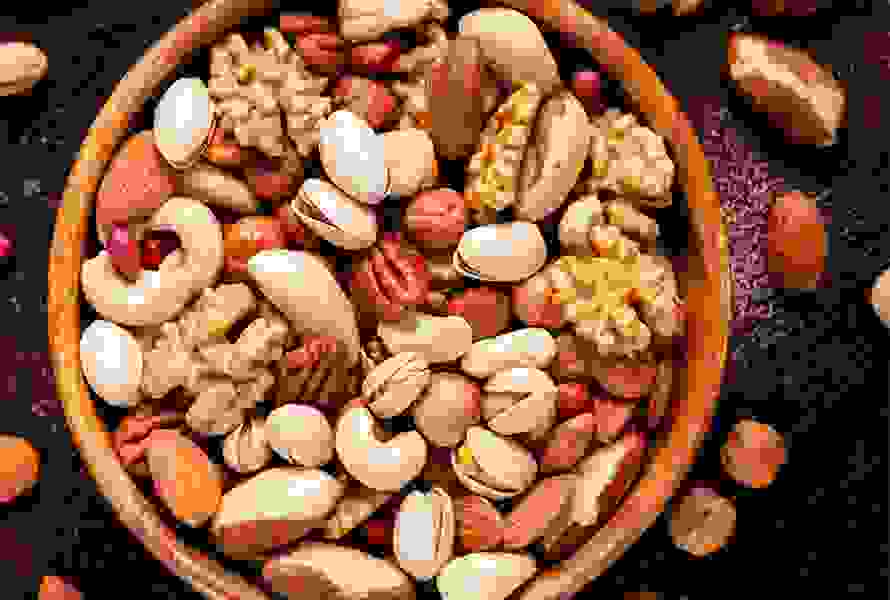 Un bol en bois contenant un mélange d’amandes, de noix et de graines de tournesol – un coup de boost naturel pour une pause énergétique

