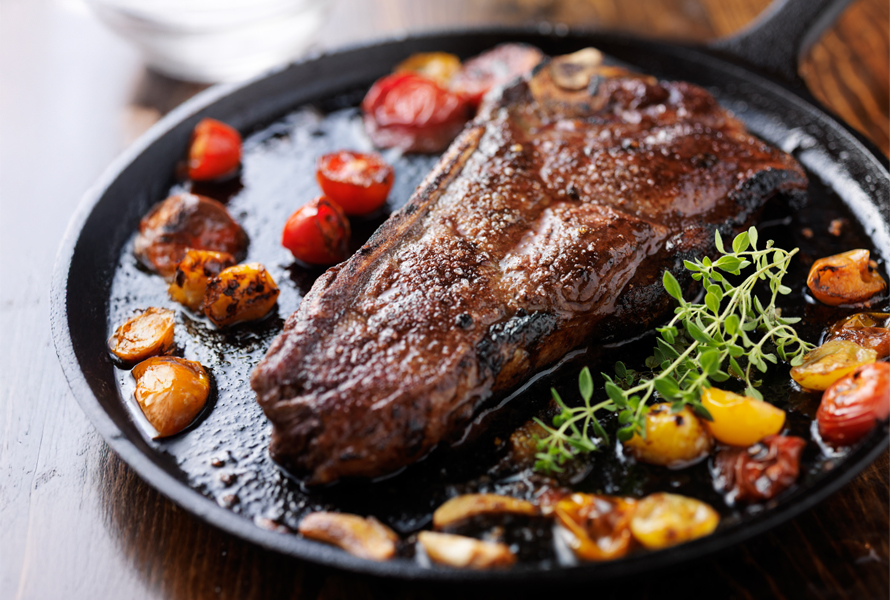 Herzhaft geniessen Ein saftiges Stück Fleisch wird in der Pfanne mit Gemüse angerichtet – ideal für bewusste Genussmomente.