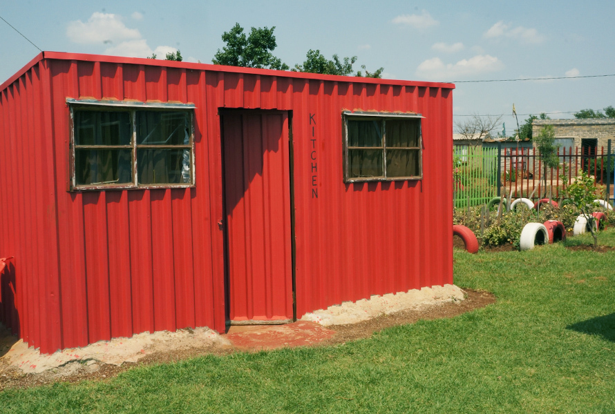 Das  Küchengebäude mit rotem Anstrich ersetzt das Provisorium und bietet endlich passende Bedingungen für die tägliche Essenszubereitung.