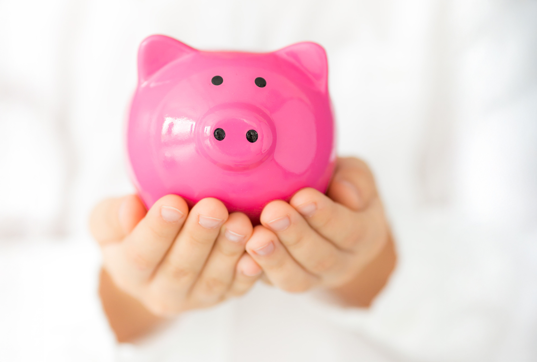 Comment PRO LIFE est-il financé? Deux mains ouvertes tiennent une tirelire rose – un symbole de gestion responsable des cotisations et de financement transparent.