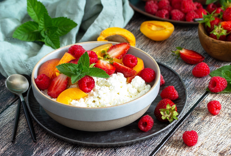 Eiweissreicher Snack mit fruchtiger Frische Eine Schale Hüttenkäse, liebevoll dekoriert mit Beeren und saisonalen Früchten – eiweissreich und angenehm leicht.