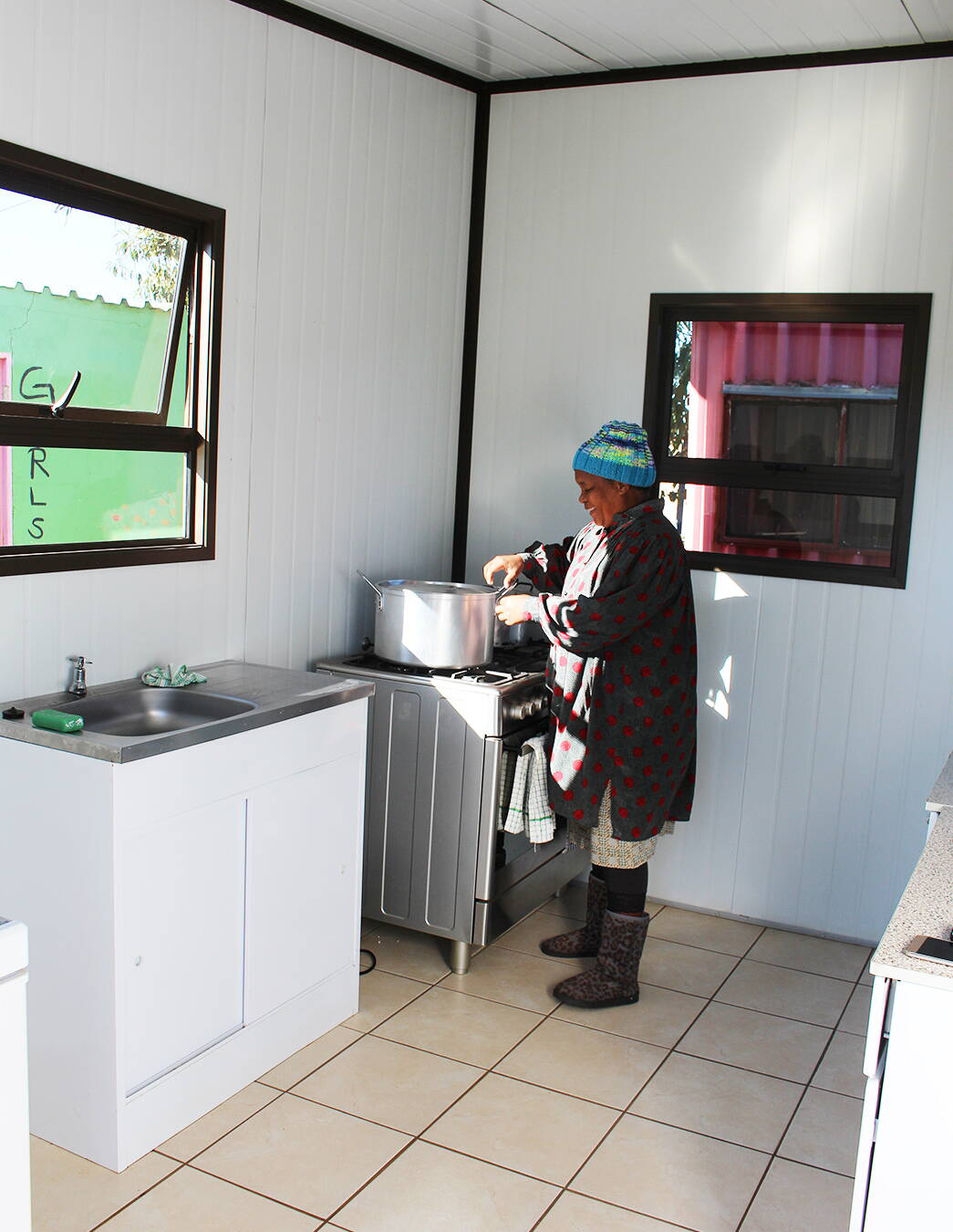 Gladys am Herd – mit Herz und Engagement In der neuen Küche bereitet Gladys mit viel Liebe eine warme Mahlzeit für die Kinder zu – ein sichtbares Zeichen des Fortschritts in Nkululeko.