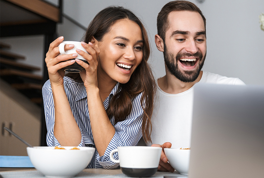 Ein junges Paar schaut gemeinsam und interessiert auf einen Laptop – entdecken Sie unsere Publikationen.