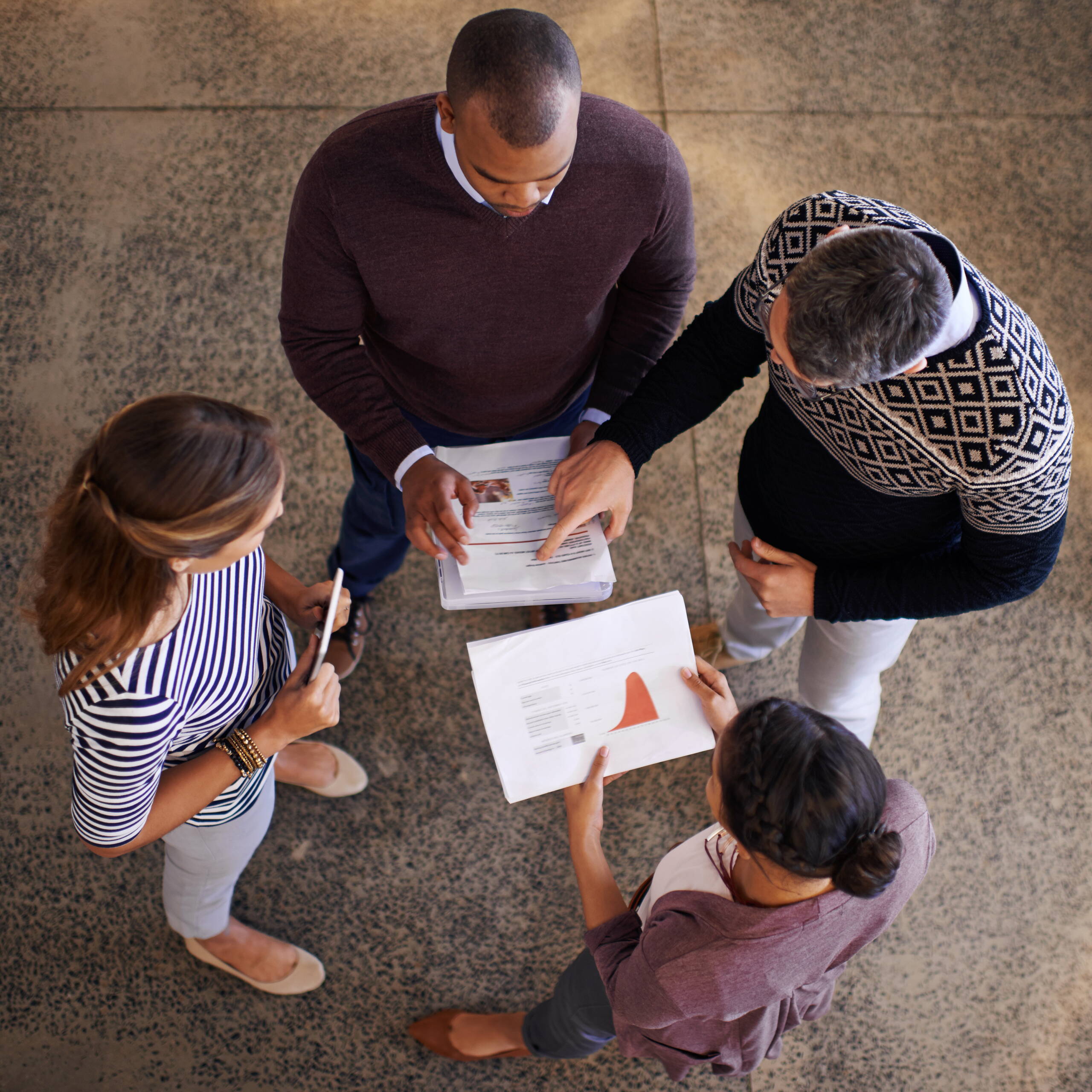 Quatre personnes discutent ensemble du contenu du rapport de gestion – l’image symbolise l’ouverture, le travail d’équipe et la responsabilité partagée pour une association transparente.