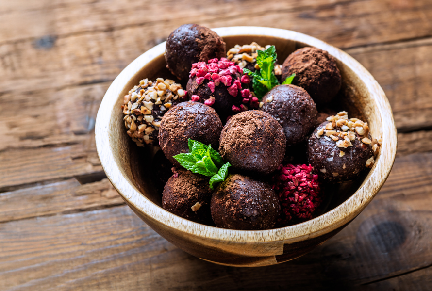 De petites boules à fort potentiel énergétique Una selezione variopinta di energy balls in una ciotola – pratiche, sazianti e ricche di ingredienti preziosi