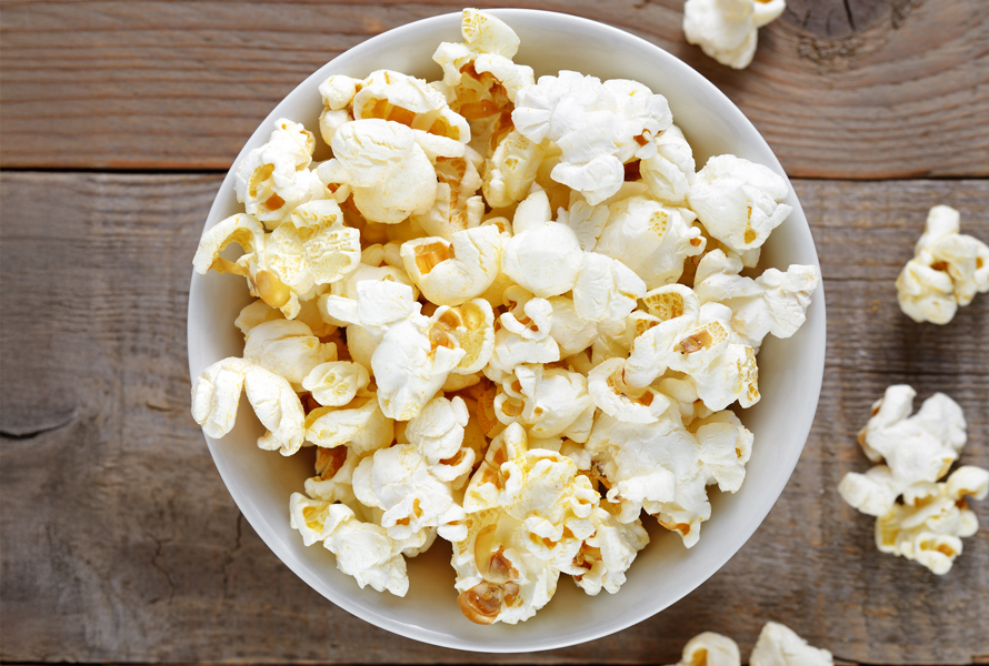 Leichter Knabberspass statt Chipsfrust Frisch gepopptes Popcorn in einer weissen Schüssel – fettarm zubereitet und perfekt für den kalorienbewussten TV-Abend.
