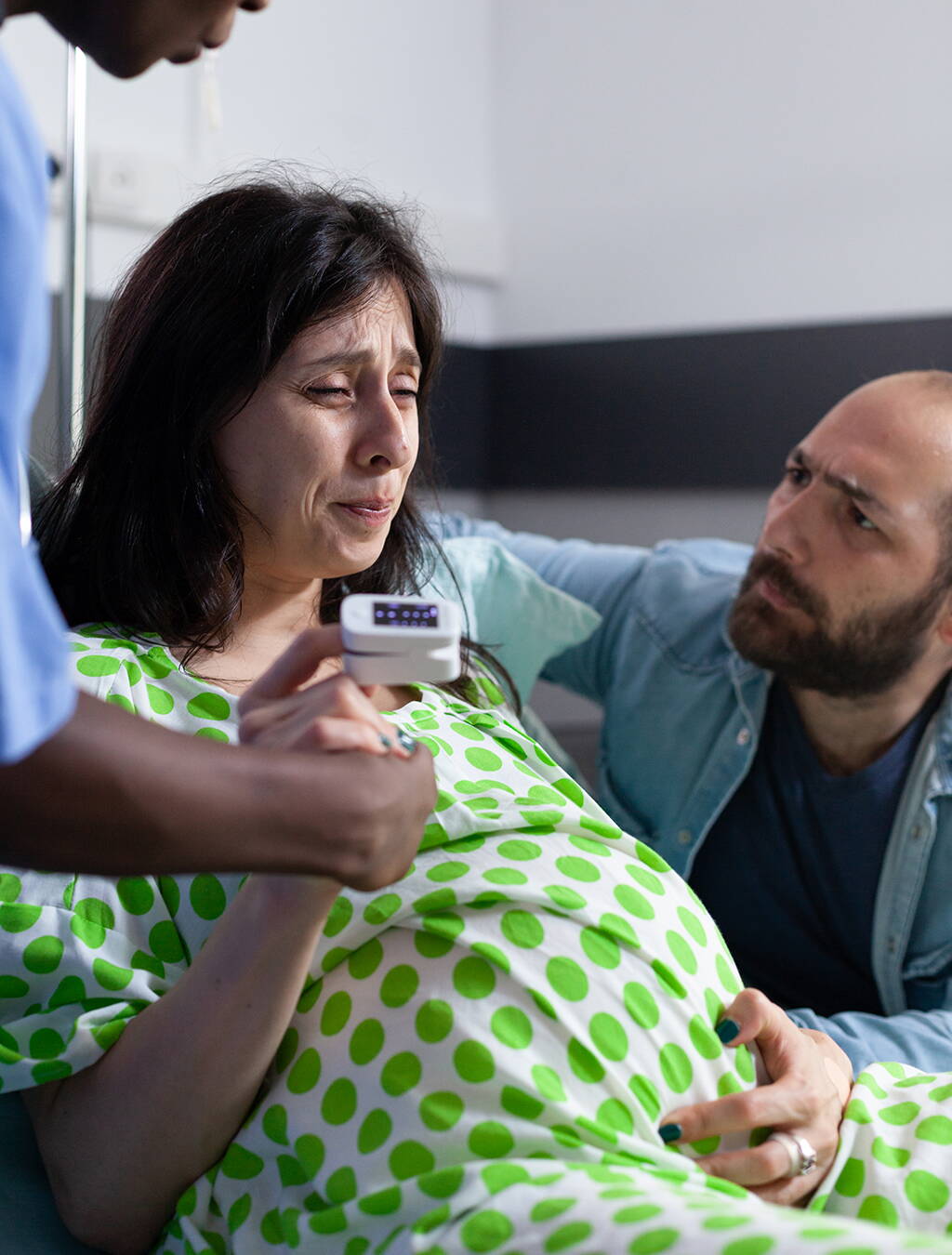 Wenn die Wehen beginnen Eine Frau in den Wehen stützt sich ab, ihr Partner kniet neben ihr und gibt ihr Halt – ein emotionaler Moment kurz vor der Geburt.