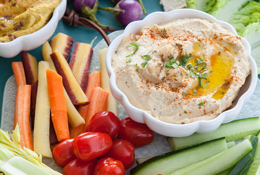 Gesunde Snacks für Schwangere Hummus mit Rüebli-, Zucchini-Sticks und Datteltomaten – ideale, nahrhafte Snacks gegen Heisshungerattacken.