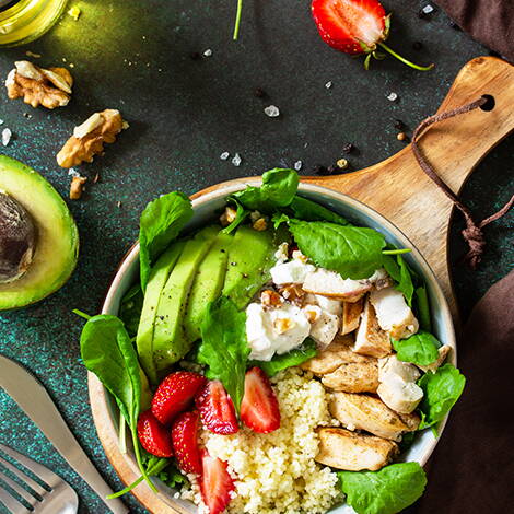 Bunte Schale mit Couscous, Poulet und Avocado Ein gesunder Mix aus Couscous, gebratenen Pouletstreifen, Avocadoscheiben, Spinat, Erdbeeren und Joghurt – vollwertig und lecker für Schwangere.