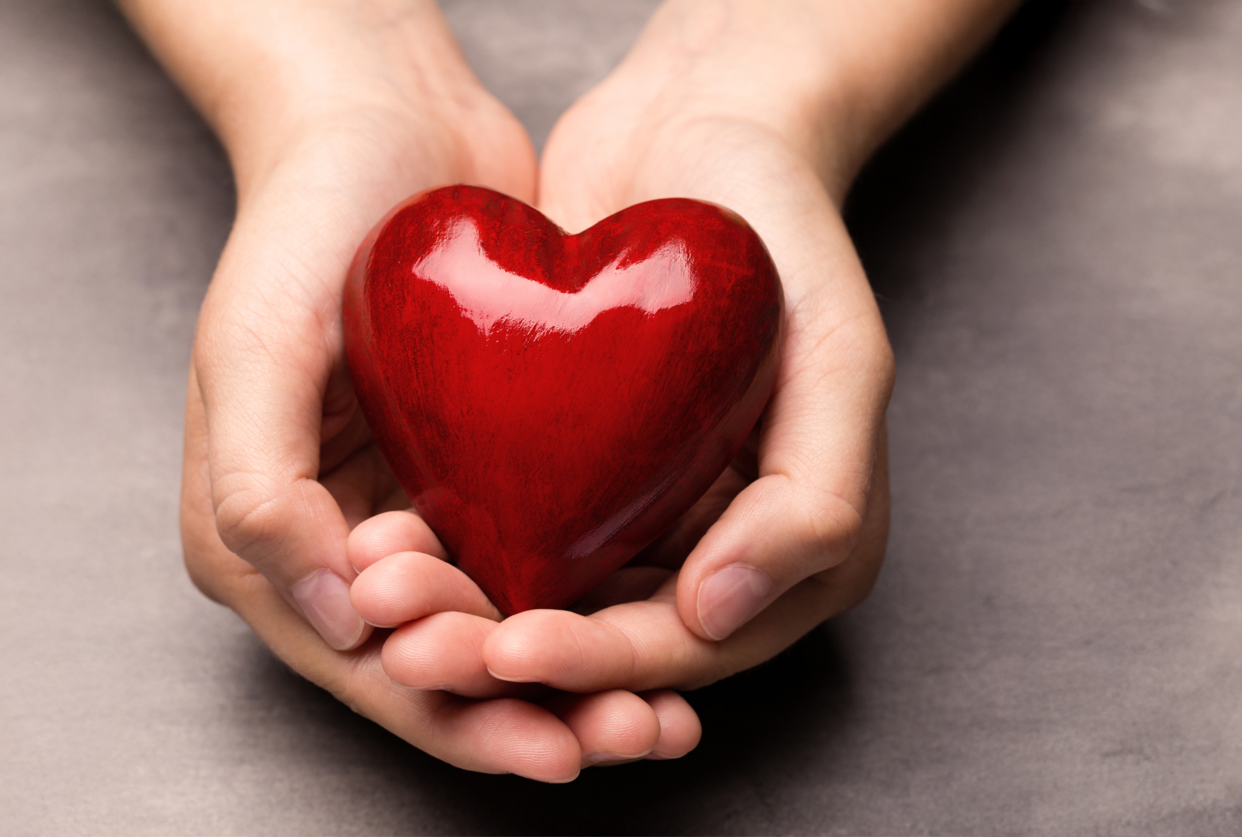 Solidarietà che conta Due mani tengono un cuore rosso – il progetto «Don del cuore» aiuta rapidamente e con discrezione i membri in difficoltà, con un impatto reale.