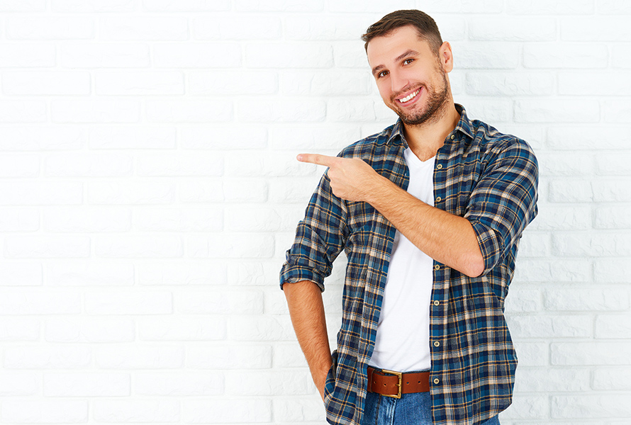 Der junge Mann zeigt auf „PRO LIFE weiterempfehlen“. Denn jede Empfehlung stärkt unsere Solidargemeinschaft – und wird mit 50 Franken belohnt.