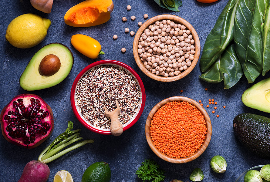 Pflanzliche Proteinpower Getrocknete Kichererbsen, rote Linsen, Quinoa, Kürbis, Avocado, Peperoni, Granatapfel und Krautstiele – perfekte Zutaten für eine nährstoffreiche vegetarische Ernährung.