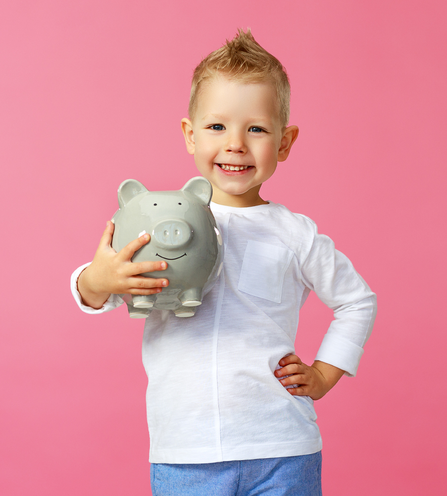 Gemeinsam Gutes tun Ein lächelnder kleiner Junge hält ein Sparschwein im Arm – jedes Engagement zählt.