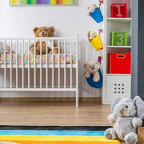 Nestbautrieb vor der Geburt Ein liebevoll eingerichtetes Babyzimmer mit Bettchen, Teppich, Regal und Kuscheltieren – ein Bild, das den Wunsch widerspiegelt, alles noch vor der Geburt fertig zu machen.