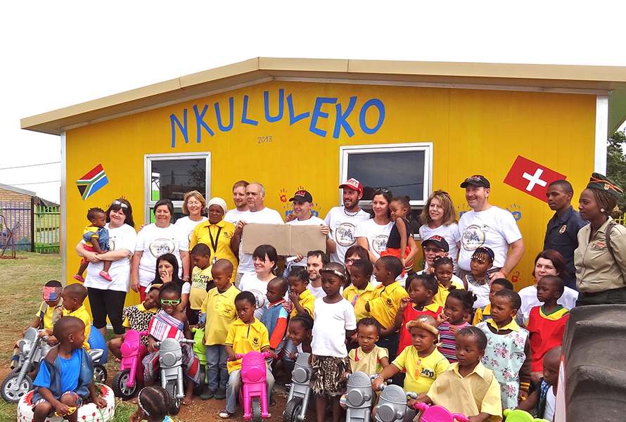 Das Bauteam steht gemeinsam mit den Kindern von Nkululeko stolz vor dem neu errichteten Gebäude – ein Moment voller Hoffnung und Zusammenhalt.