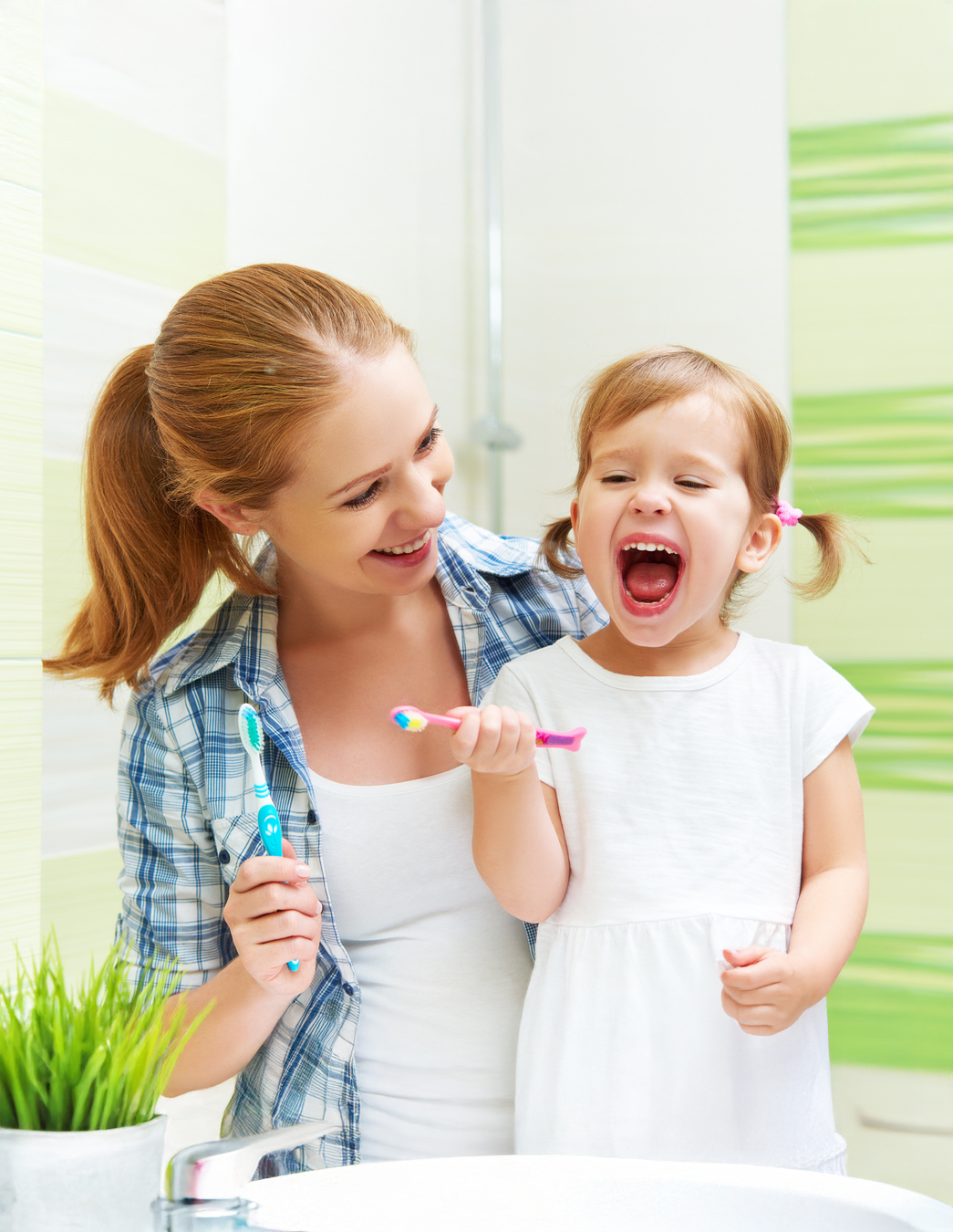 Ein kleines Mädchen steht mit seiner Mutter am Lavabo – tägliche Zahnpflege beginnt zu Hause, die finanzielle Unterstützung kommt von PRO LIFE.