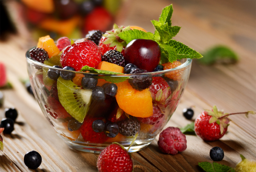Una carica fruttata di vitamine per una pausa sana Un’insalata di frutta variopinta in una ciotola di vetro – ideale con frutta di stagione, fornisce molte vitamine e fibre per una pausa salutare