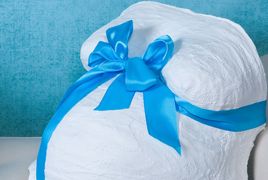 Gipsabdruck vom Babybauch Ein fertiger Gipsabdruck eines Babybauchs mit blauer Schleife – eine kreative Erinnerung an die Kugelzeit.