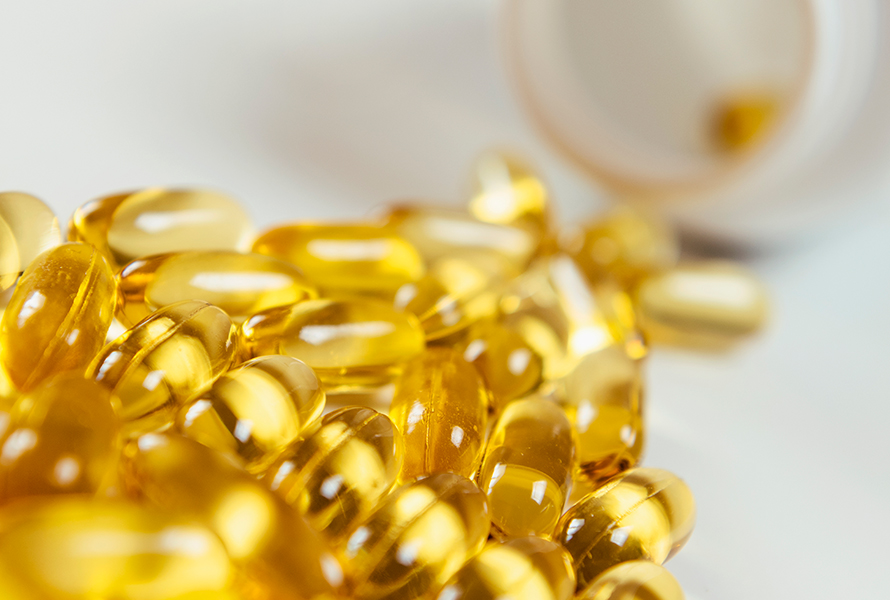 Goldgelbe Vitamin-D-Kapseln, die helfen können, einen Mangel auszugleichen und das Wohlbefinden während der Schwangerschaft zu unterstützen.