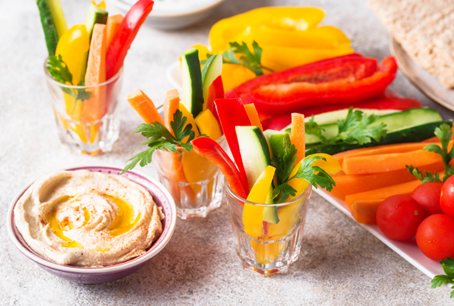 Frisch, bunt und gesund – Gemüsesticks mit Hummus Ein Glas mit knackigen Rüebli-, Peperoni und Zucchinisticks, daneben eine Schale cremiger Hummus. Der perfekte Snack für zwischendurch – voller Nährstoffe und in wenigen Minuten zubereitet.