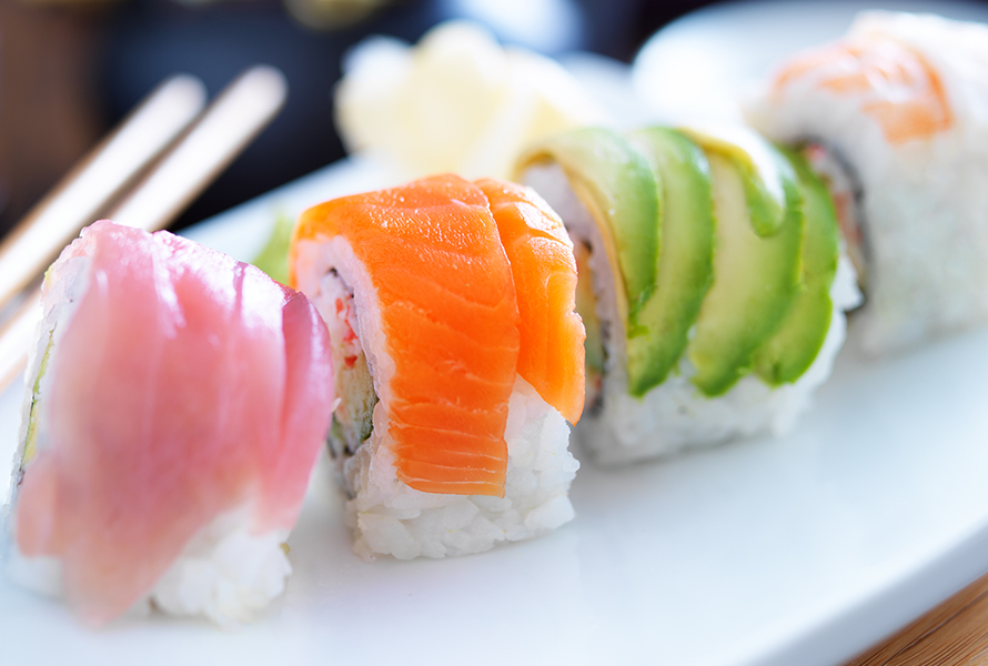 Sushi – Vorsicht in der Schwangerschaft Eine weisse Platte mit verschiedenen Sushi-Stücken – Rohfisch und ungekochte Speisen sind in der Schwangerschaft zu meiden.